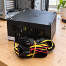 Fuente de poder ATX Unitec 750W para computador — fuente en mesa de reparación con cables apoyados