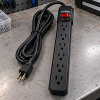 Multitoma Unitec de 6 tomas con cable de 3 metros — multitoma sobre un banco de trabajo