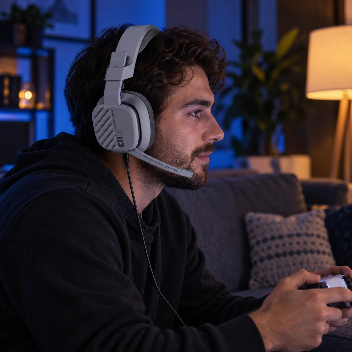 Diadema Logitech ASTRO A10 Gen 2 gris para PS5, PS4 y PC — jugador usando la diadema en una sala nocturna